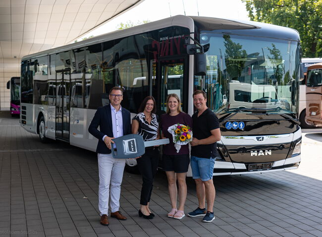 Familie Piendl bei der Übergabe mit Blumenstrauß vor dem Bus