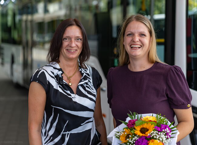 Übergabe mit Blumenstrauß