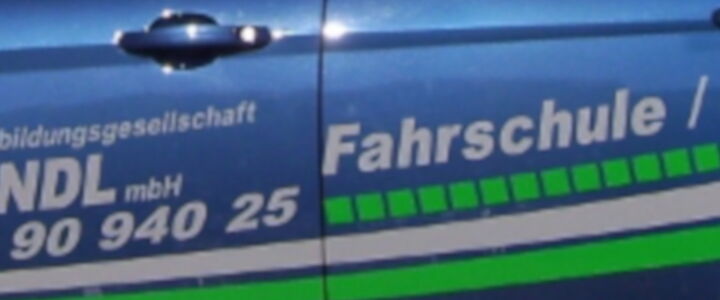 Bildausschnitt Firmenauto mit VBG-Werbung Fahrschule und Weiterbildung