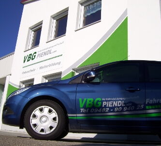 Auto mit VBG-Beschriftung vor Piendl-Firmengebäude
