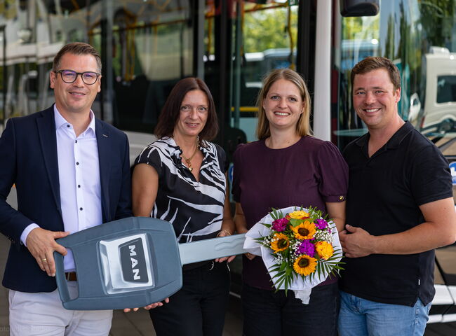 Familie Piendl bei der Übergabe mit Blumenstrauß vor dem Bus